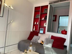 a room with a bed with a mirror and red shelves at Apartment Les Jardins du Port-10 by Interhome in Le Grau-du-Roi
