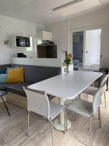 a white dining room table with chairs and a couch at Holiday Home Natuurlijk de Veenhoop by Interhome in De Veenhoop