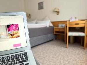 a laptop computer sitting on a table in a hotel room at Hotel zum Rosenteich in Bad Zwischenahn