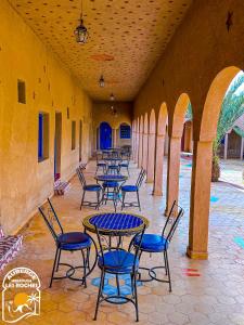 a row of tables and chairs in a building at Riad Les Roches Merzouga in Merzouga