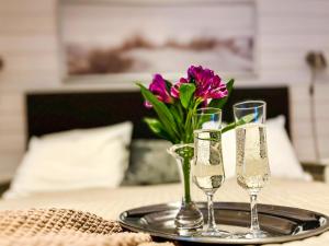 een tafel met twee champagneglazen en een vaas met bloemen bij Holiday Home Kasnäs marina b 15 by Interhome in Kasnäs