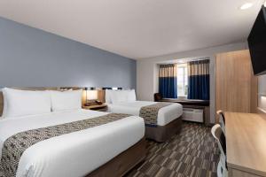ein Hotelzimmer mit zwei Betten und einem Schreibtisch in der Unterkunft Microtel Inn and Suites - Zephyrhills in Zephyrhills