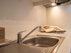 a kitchen sink with a book on top of it at Apartment Dina with parking and shared pool by Interhome in De Haan +19 photos