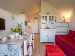 a kitchen and living room with a table and a couch at Apartment Dina with parking and shared pool by Interhome in De Haan