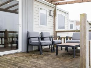 a porch with chairs and a table and a bench at Holiday Home Natuurlijk de Veenhoop by Interhome in De Veenhoop