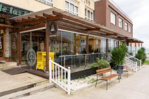 a store with a bench in front of a building at Hotel Crisol de las Rías in Miño