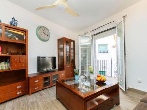 a living room with a table and a clock on the wall at Holiday Home Cap de Tossa by Interhome in Tossa de Mar