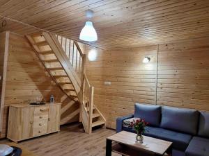 a living room with a blue couch and a staircase at Domki Letniskowe Vitamin Sea in Sarbinowo