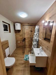 uma casa de banho com um lavatório, um chuveiro e um WC. em Domki Letniskowe Vitamin Sea em Sarbinowo
