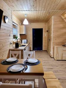 a kitchen and dining room with a table and chairs at Domki Letniskowe Vitamin Sea in Sarbinowo