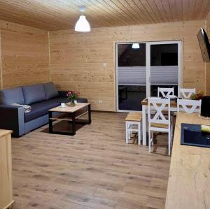 a living room with a couch and a table at Domki Letniskowe Vitamin Sea in Sarbinowo +10 photos