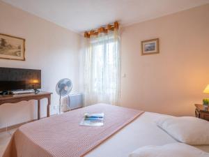 - une chambre avec un lit et un livre dans l'établissement Apartment Le Grand Parc-9 by Interhome, à Saint-Aygulf
