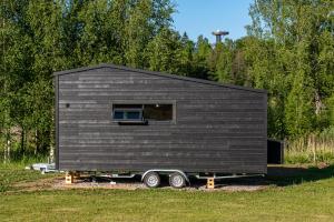 a black tiny house on a trailer in a field at Villa Tiny in Rõuge