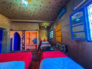 Riad Les Roches Merzouga في مرزوقة: غرفة نوم بسريرين في غرفة