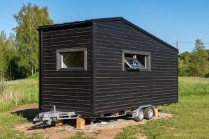 a black tiny house on a trailer in a field at Villa Tiny in Rõuge