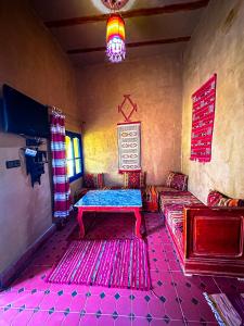 a living room with two couches and a tv at Riad Les Roches Merzouga in Merzouga