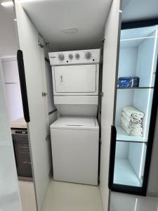 a small white refrigerator in a small kitchen at Lecheria Thai 3hab 2baños in El Morro de Barcelona