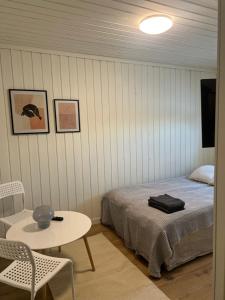 Schlafzimmer mit einem Bett, einem Tisch und einem Stuhl in der Unterkunft Gamle Oslo Apartments - Enebakkveien in Oslo
