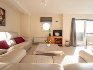 ein Wohnzimmer mit weißen Sofas und einem Tisch in der Unterkunft Apartment Blutsyde Promenade-35 by Interhome in Bredene
