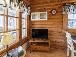 a living room with a tv in a log cabin at Holiday Home Hallan-etappi b paritalo by Interhome in Hyrynsalmi