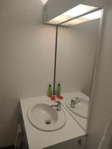 ein Bad mit einem Waschbecken und einem Spiegel in der Unterkunft Un temps pour vous in Ammerschwihr