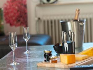 una mesa con dos copas de vino y una tabla de cortar con queso en Apartment Knurrhahn by Interhome, en Norddeich