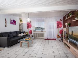 sala de estar con sofá y TV en Apartment Knurrhahn by Interhome, en Norddeich