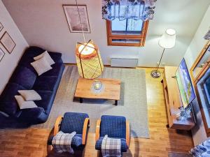 a living room with a couch and a table at Holiday Home Alppitalo sinitähti 9 apt 3 by Interhome in Tahkovuori