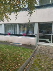 um edifício com janelas com cestos cor-de-rosa à frente em Un temps pour vous em Ammerschwihr