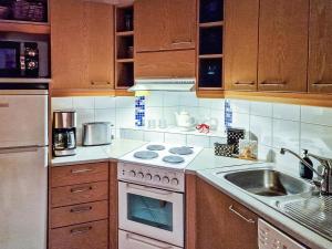 eine Küche mit einem weißen Herd oberer Ofen neben einer Spüle in der Unterkunft Holiday Home Alppitalo sinitähti 9 apt 3 by Interhome in Tahkovuori