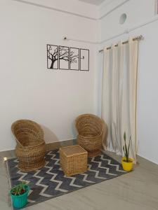 a room with three wicker chairs and a rug at Relaxing Oasis in Tezpur