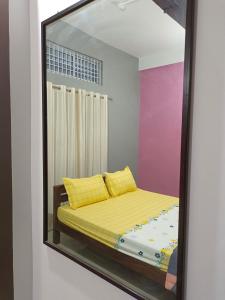 een spiegelbeeld van een bed in een kamer bij Relaxing Oasis in Tezpur