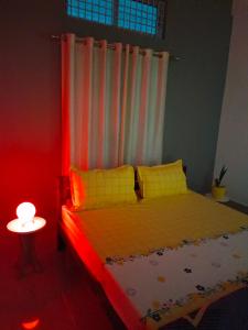 een slaapkamer met een bed met een rood licht bij Relaxing Oasis in Tezpur