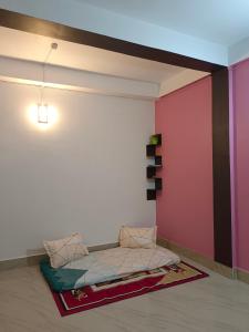 een bed in een kamer met een roze muur bij Relaxing Oasis in Tezpur