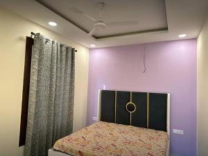 1 dormitorio con cama y pared púrpura en Serene, charming and party friendly Farmhouse sec 150 Noida, en Greater Noida