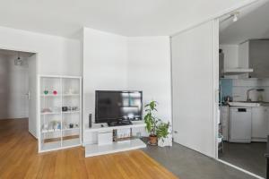 ein weißes Wohnzimmer mit einem Flachbild-TV in der Unterkunft Your home in Gentilly in Gentilly