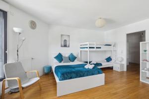 ein weißes Schlafzimmer mit einem Bett und einem Stuhl in der Unterkunft Your home in Gentilly in Gentilly