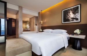 a bedroom with a large white bed and a table at Grand Hyatt Hong Kong in Hong Kong