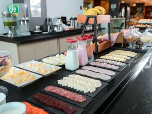 a buffet with different types of food on a table at ibis Presidente Prudente Manoel Goulart in Presidente Prudente