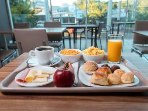 a tray of breakfast foods and orange juice on a table at ibis Presidente Prudente Manoel Goulart in Presidente Prudente