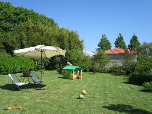 um guarda-chuva e uma cadeira e uma casa de brincar num quintal em Holiday Home De Pedral by Interhome em Castelo do Neiva