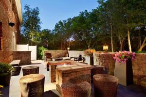 a patio with a fire pit and stools at Hilton Garden Inn Rochester/Pittsford in Bushnell Basin