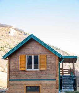 mały drewniany dom z oknem i schodami w obiekcie Green Cottage Nikola 