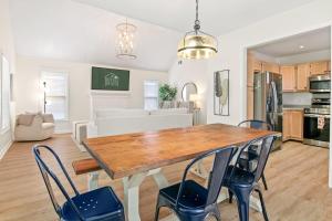 a kitchen and living room with a wooden table and chairs at Renovated Charleston Oasis Mins to Dtwn and Beach in Charleston