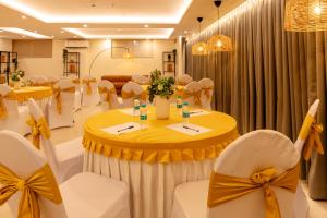 a banquet hall with tables and chairs with bows at Earth Hotels in Bengaluru