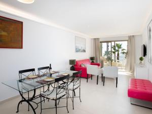 a living room with a table and a red couch at Apartment Balcón de Cotobro I by Interhome in Almuñécar