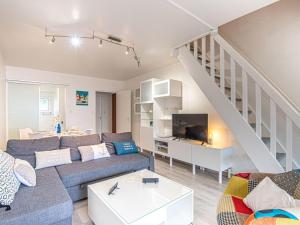 a living room with a couch and a staircase at Apartment Ker Eol by Interhome in Carnac +14 photos