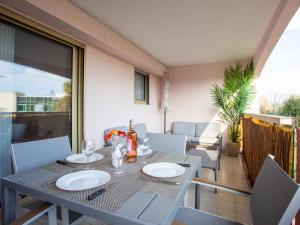 a table with plates on it on a balcony at Studio Tivoli des Anges by Interhome in Villeneuve-Loubet
