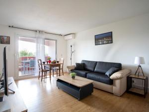 ein Wohnzimmer mit einem Sofa und einem Tisch in der Unterkunft Studio Tivoli des Anges by Interhome in Villeneuve-Loubet