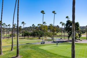a man playing golf in a park with palm trees at The Hotel at La Valle in Rancho Santa Fe